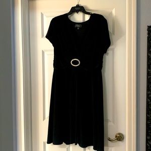 Calf-length black dress. Crystal buckle detail at empire waist.